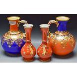 A matched pair of Samuel Alcock single handled vases with gilded Persian style flowers on vivid