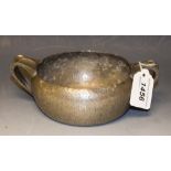 A Tudric pewter two-handled porringer, hammered overall, 18cm wide over handles, impressed mark,