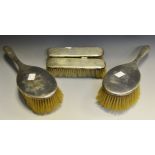 An Art Deco silver four piece dressing table set, mirror, a hair brush and two clothes brushes,