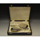 An Elizabeth II silver dressing table suite, comprising hand mirror, hair brush and comb,