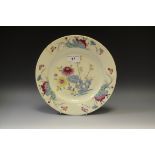 An 18th century Bow circular plate, painted in Famille Rose manner with holed rock,