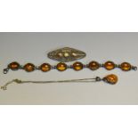 A silver mounted amber pendant; an amber brooch;