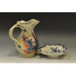 An English pottery jug, decorated with hut and foliage, in iron red and cobalt blue,
