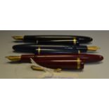 A blue Parker fountain pen ; a red duofold fountain pen;