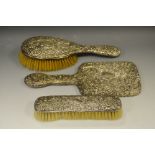 An Edwardian silver and three piece dressing table set, mirror, brush cloths brush,