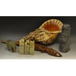 A Conch shell; an Indonesian hardwood carving; an Easter Island marble carving;