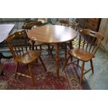 A modern circular kitchen table and four spindle back chairs
