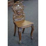 A Gothic revival hall chair, heavily carved back, shaped wooden seat, carved forelegs,