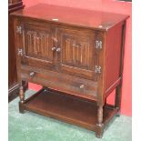 An oak Priory style side cabinet, two linenfold doors over long drawer, undertier,