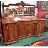 A large Victorian mahogany break front mirror back sideboard, the arched mirror with carved crest,