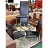 A modern designer circular glass and chrome dining table and four chairs