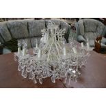 A large twelve branch wrought metal chandelier, faceted droppers.