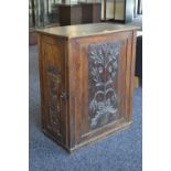 An early 19th century oak cupboard, later carved panels added.