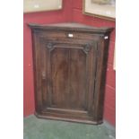 A George III oak splay fronted wall hanging corner cupboard,