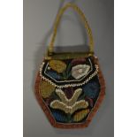 A 19th century beadwork purse, colourfully worked with stylised flowers, rope twist handle,