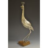 An Oriental silvered model, of an exotic ho-ho bird, mahogany base,