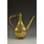 An 18th century Indian brass ewer, of Islamic shape, hinged cover, scroll handle with bud terminal,