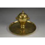 A Victorian brass desk inkwell, hinged cover with knop finial, parakeet masks to sides,