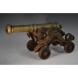 An early 20th century brass and cast iron model canon, the carriage cast with dragons,