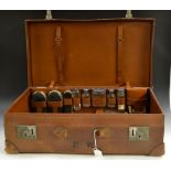 A George V gentleman's leather suitcase, fitted for dressing with silver brushes, shaving kit,