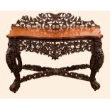 A 19th century Burmese hardwood serving table, shaped back, slightly oversailing top,