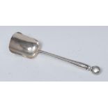 An Arts and Crafts silver caddy or sugar spoon, bun shaped terminal, lobed stem, shovel shaped bowl,