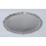 A George V shaped circular tray, beaded rim with stylised leaves and scrolls, 31cm diam,