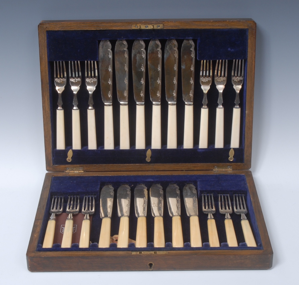 A George V silver fish service, comprising twelve pairs of knives and forks,