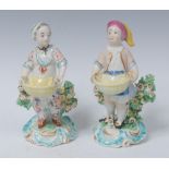 A pair of Derby Patch Mark figures, Dessert Gardeners, he in a stocking cap, smock and blue apron,