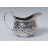 A George III silver boat shaped cream jug, reeded rim, angular scroll handle,