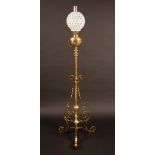 A Victorian brass floor standing extending oil lamp, globular uranium shade , brass reservoir,