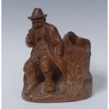 A Black Forest figural table vesta, carved as a bearded Bavarian gentleman beside a tree stump,