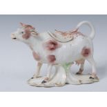 A Derby creamer and cover, in the form of a horned cow, standing on all four, rust patch markings,
