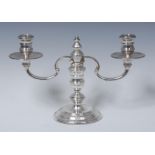 A George I style silver two-light candelabrum, reel shaped sconces, dished drip pans,