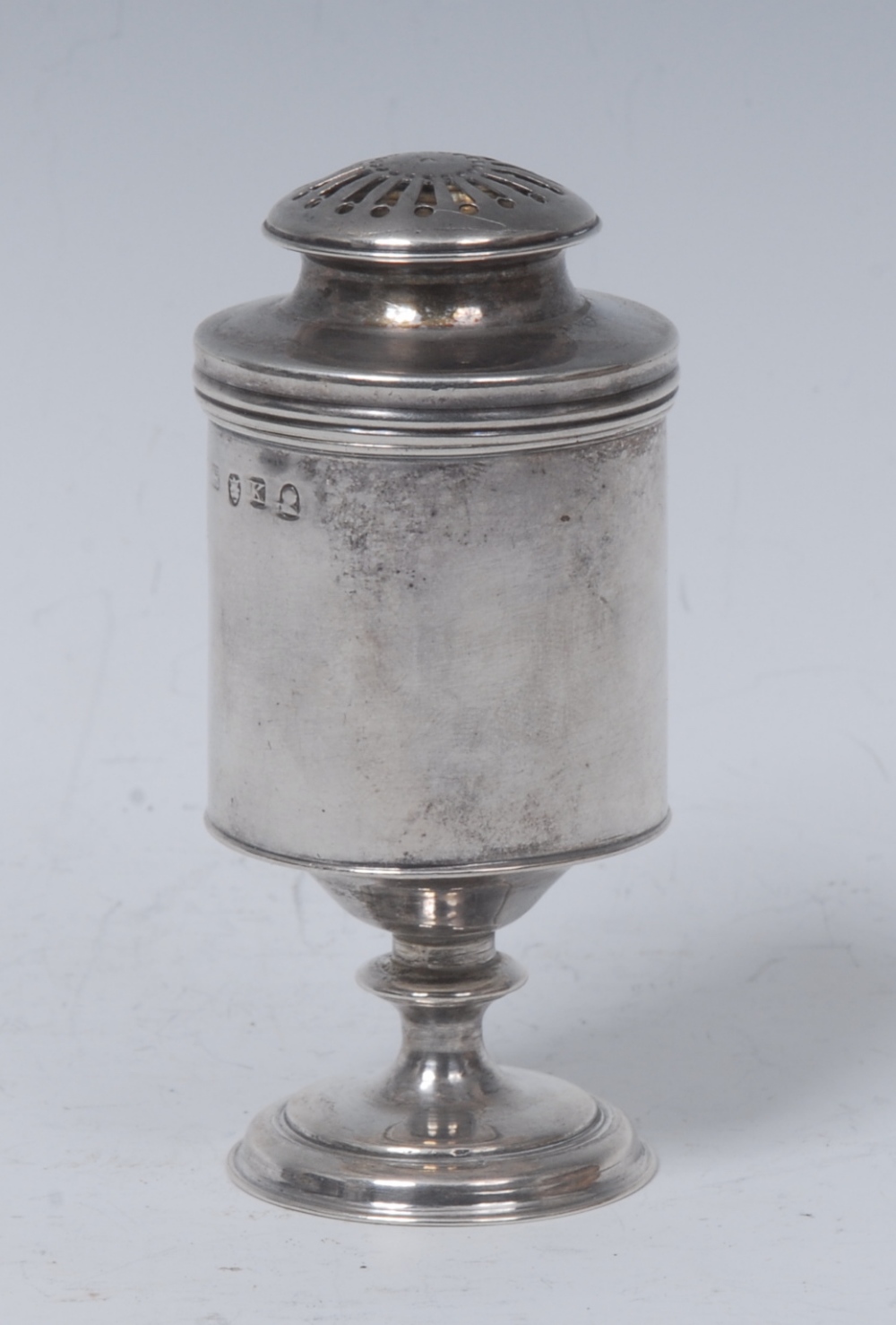 A George III silver cylindrical pedestal spice caster or muffineer, domed pierced bun shaped cover,