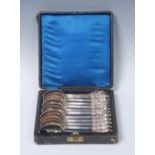 A set of twelve Russian silver teaspoons, leafy cartouche shaped terminals, crested,