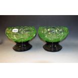 A pair of large green glass bowls on stands