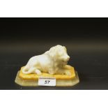 A carved alabaster and onyx statue, recumbent lion,14cm long,