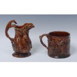 A 19th century Staffordshire treacle glazed frog mug,in relief with jolly topes and vine leaves,