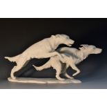 A Kaiser porcelain model of two bounding dogs, signed G.