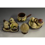A Torquay Pottery Mottoware three-piece condiment stand, decorated with black cockerel,
