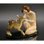 A Goldscheider figure, of a kneeling naked girl with a faun, oval black base, 16cm high, shape no.