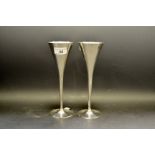 A pair of white coloured metal champagne flutes in the manner of Christopher Dresser