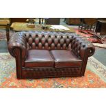 A contemporary faux leather oxblood red Chesterfield two seater sofa 72cm x 760cm x 90cm