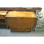 An early 20th century panelled oak gateleg dining table, c.