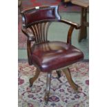 A late Victorian office swivel chair, padded top rail, horseshoe arm rail, fan lath back splat,