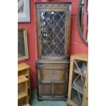 An oak floor standing corner cupboard, leaded glazed door to top, panel door to base.