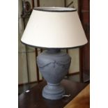 A large ceramic urn shaped table lamp with shade