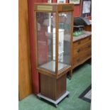 A shop display cabinet on wheeled plinth. 149cm high x 40cm square.