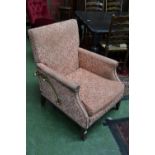 An early 20th century reclining armchair, scrolled arms, brass incliners to sides.